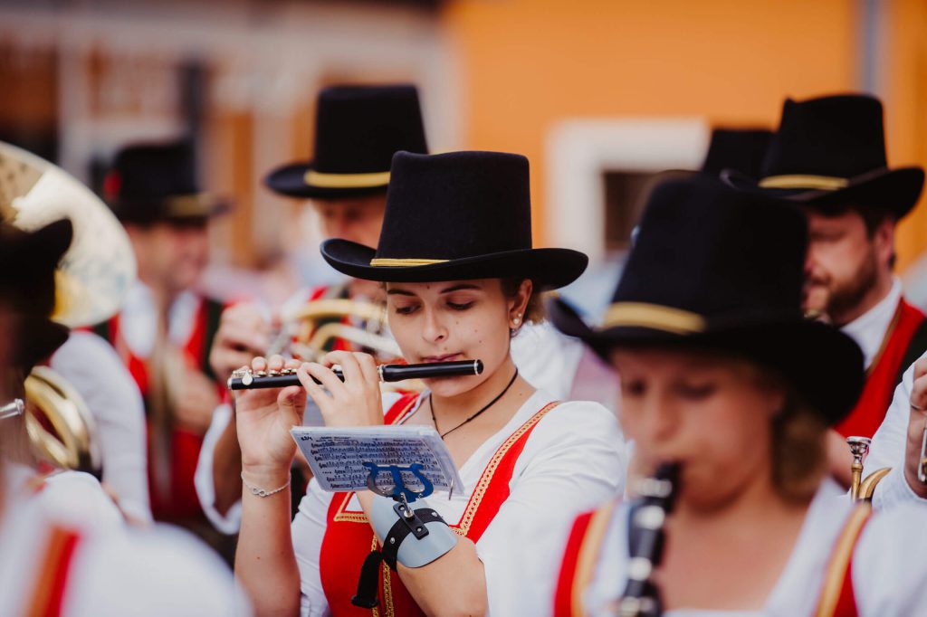 Musikantinnen in traditionellen Trachten spielen Flöte beim Bauernherbst im Salzburger Land.