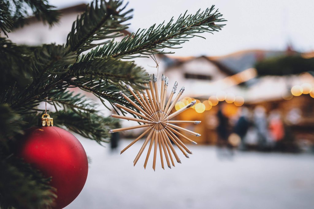Weihnachtliche Dekoration mit rotem Ball und Star aus Stroh am Mittersiller Adventmarkt.